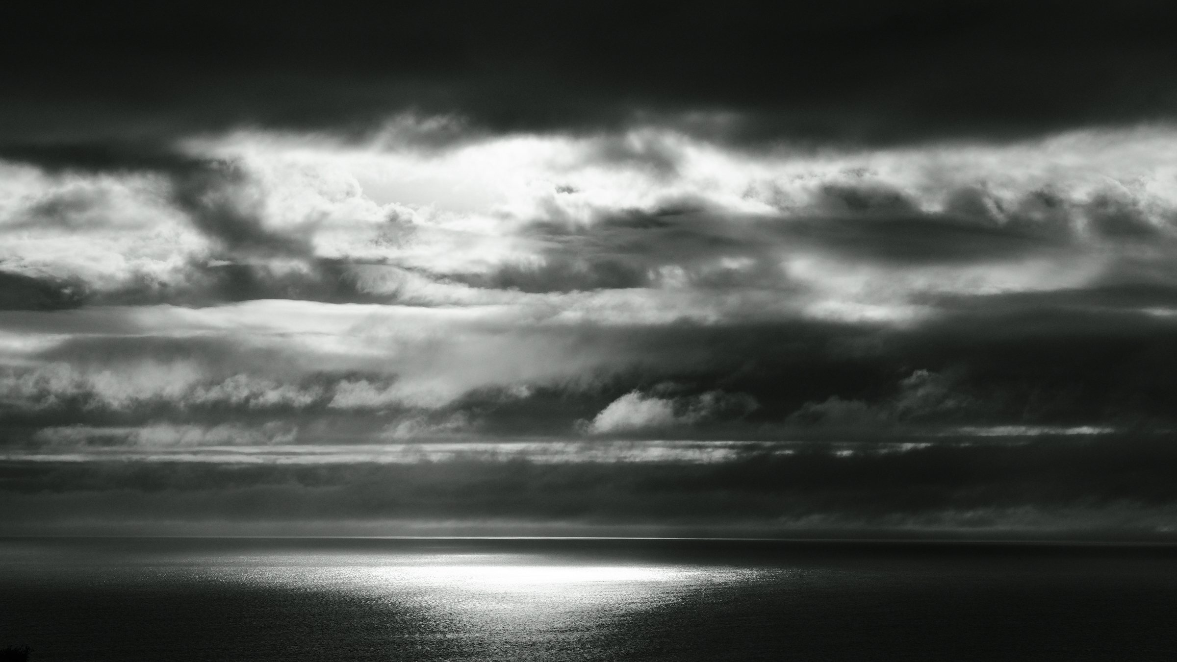 Light breaking through storm clouds onto a dark sea